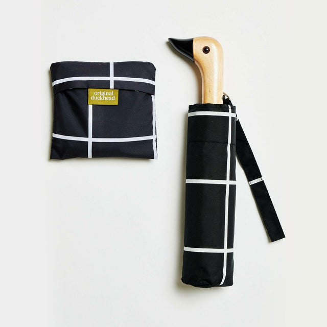 Foldable umbrella with black and white grid pattern and duckhead wooden handle with a matching tote bag