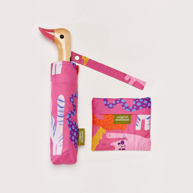 Pink umbrella with a duck handle and matching pouch on a white background