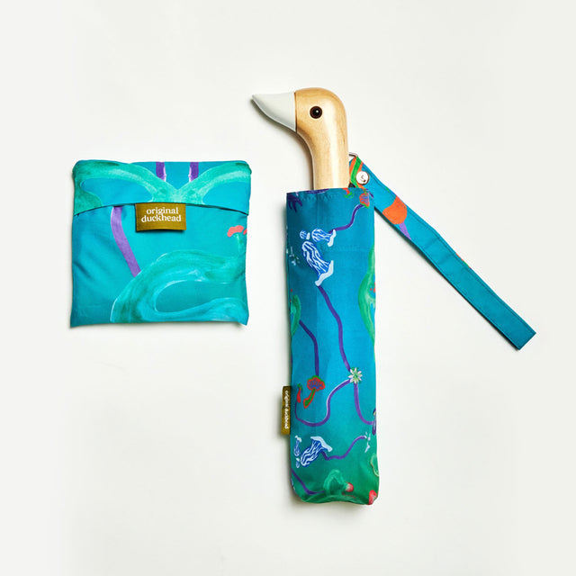 Colorful umbrella with duck-shaped handle and matching folded tote bag on a white background