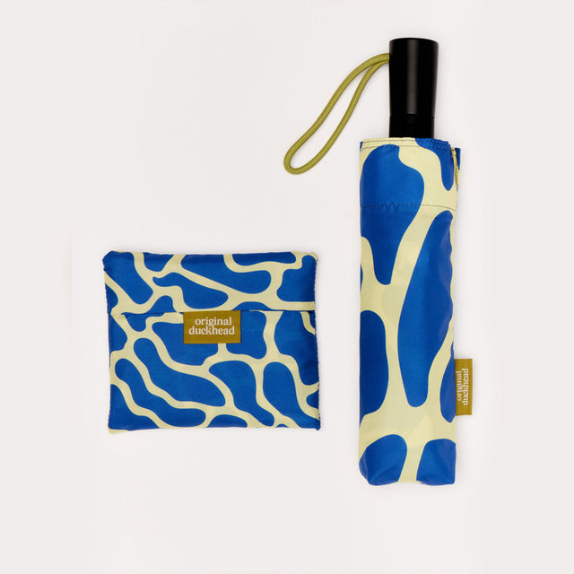 Foldable umbrella with blue and beige pattern and matching pouch on a white background