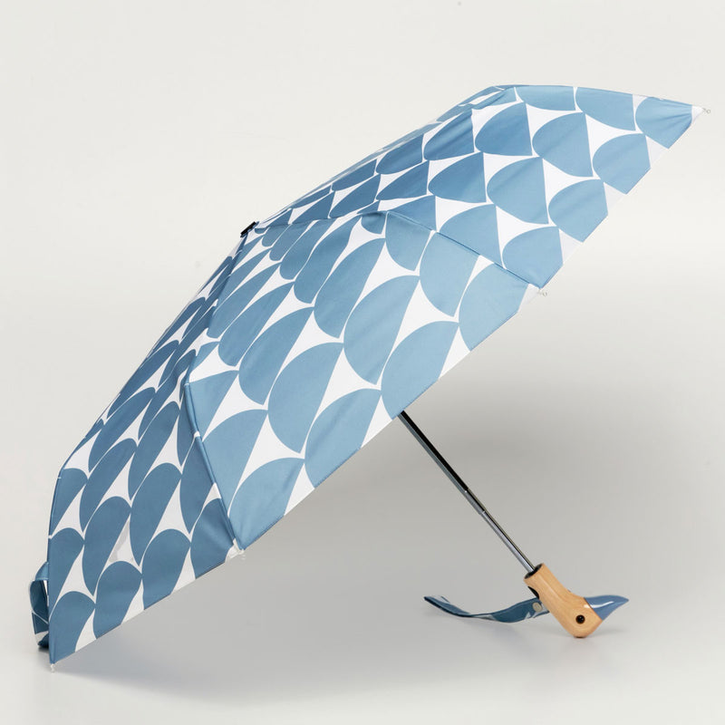Blue patterned umbrella with a wooden handle on a light gray background