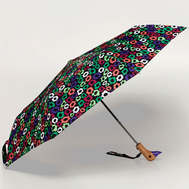 Colorful patterned umbrella with duckhead wooden handle on a light gray background