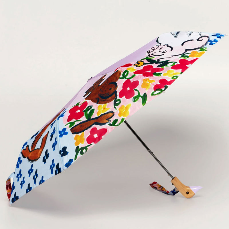 Colorful umbrella with floral and animal design on a light gray background