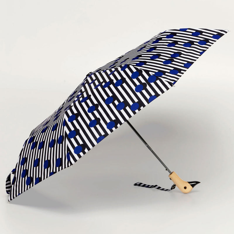 Foldable umbrella with black and white pattern and blue dots on a light gray background
