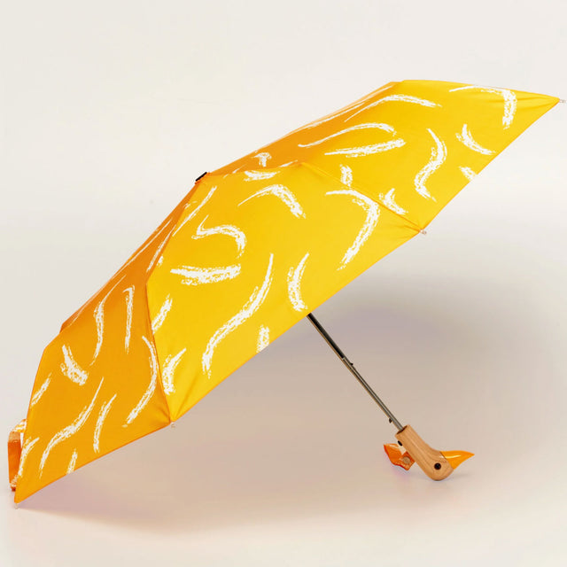Yellow umbrella with white patterns on a light gray background