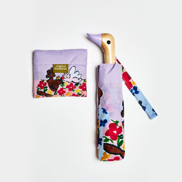Floral-patterned umbrella with a duckhead carved wooden handle and matching pouch on a white background