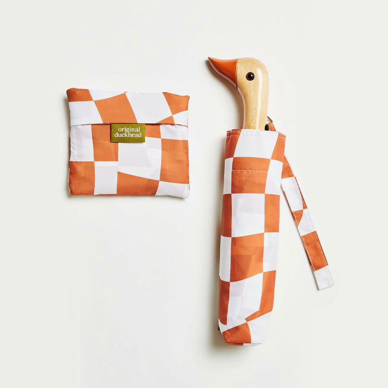 Checkered umbrella with wooden handle and matching folded tote bag on a light background