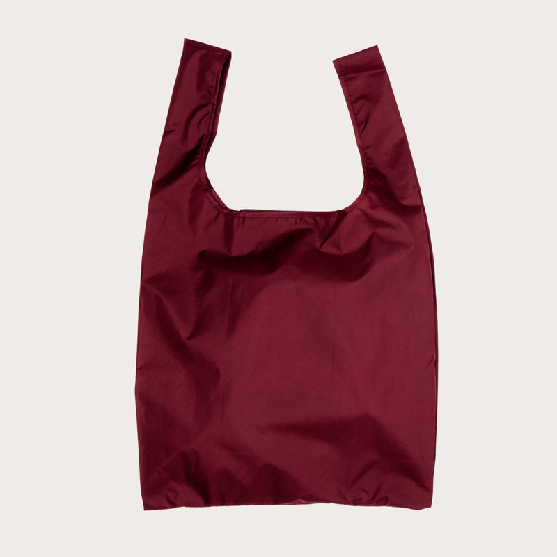 Cherry red reusable shopping bag on a light plain background